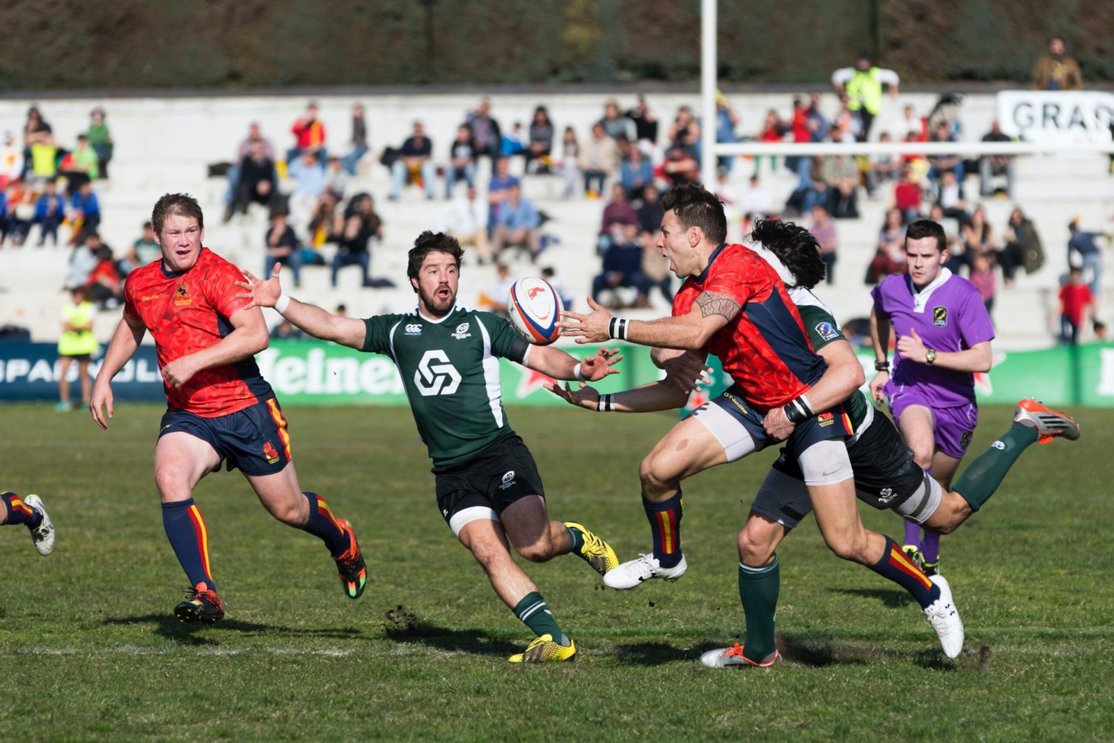 five men playing rugby during daytime